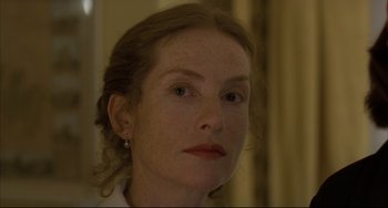 Movie still from “The Piano Teacher” (2001), directed by Michael Haneke – A person wearing a white shirt; Close Up shot, Over the shoulder angle