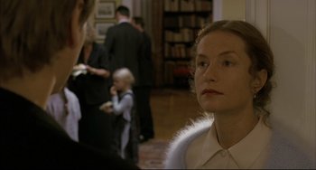 Movie still from “The Piano Teacher” (2001), directed by Michael Haneke – A woman in a white shirt is looking to her left; Close Up shot, Over the shoulder angle