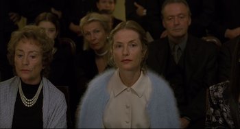 Movie still from “The Piano Teacher” (2001), directed by Michael Haneke – A group of people sitting in front of a camera; Close Up shot, Over the shoulder angle