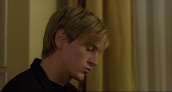 Movie still from “The Piano Teacher” (2001), directed by Michael Haneke – A person wearing a black shirt; Close Up shot, Low angle