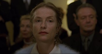 Movie still from “The Piano Teacher” (2001), directed by Michael Haneke – A person wearing a white shirt; Close Up shot, Over the shoulder angle
