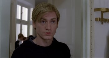 Movie still from “The Piano Teacher” (2001), directed by Michael Haneke – A person wearing a black shirt; Close Up shot, High angle