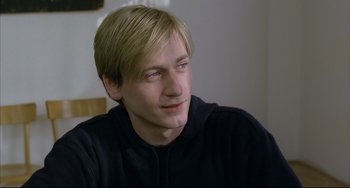 Movie still from “The Piano Teacher” (2001), directed by Michael Haneke – A person sitting in front of a window; Close Up shot, High angle