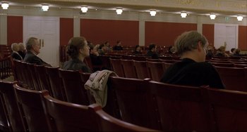 Movie still from “The Piano Teacher” (2001), directed by Michael Haneke – People are sitting in rows of seats in a theater; Wide shot, High angle