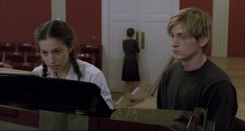 Movie still from “The Piano Teacher” (2001), directed by Michael Haneke – A man and a woman standing next to each other in front of a door; Medium shot, Over the shoulder angle