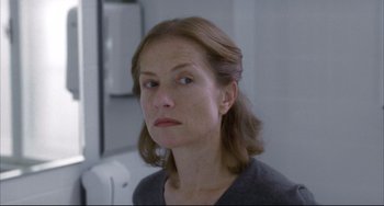 Movie still from “The Piano Teacher” (2001), directed by Michael Haneke – A person looking at the camera; Close Up shot, Over the shoulder angle