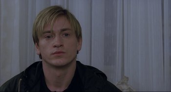 Movie still from “The Piano Teacher” (2001), directed by Michael Haneke – A person wearing a black shirt; Close Up shot, Over the shoulder angle