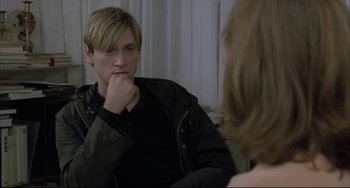 Movie still from “The Piano Teacher” (2001), directed by Michael Haneke – A man sitting in front of a woman in front of a mirror; Close Up shot, Over the shoulder angle