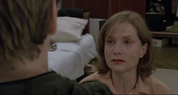 Movie still from “The Piano Teacher” (2001), directed by Michael Haneke – A woman sitting in front of a man in front of a bed; Close Up shot, Over the shoulder angle