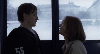 Movie still from “The Piano Teacher” (2001), directed by Michael Haneke – A man and a woman standing next to each other; Close Up shot, Over the shoulder angle