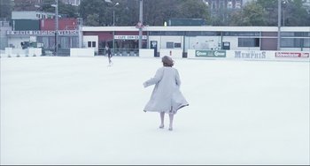 Movie still from “The Piano Teacher” (2001), directed by Michael Haneke – A woman walking in the snow in a white coat; Extreme Wide shot, High angle
