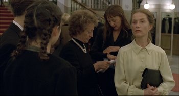 Movie still from “The Piano Teacher” (2001), directed by Michael Haneke – A group of women standing around each other; Medium shot, Over the shoulder angle