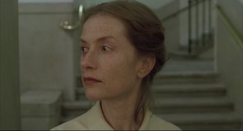 Movie still from “The Piano Teacher” (2001), directed by Michael Haneke – A person wearing a white shirt; Close Up shot, Low angle