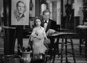 Movie still from “The Picture of Dorian Gray” (1945), directed by Albert Lewin – A man and a little girl sitting in front of a painting; Medium shot, High angle