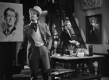 Movie still from “The Picture of Dorian Gray” (1945), directed by Albert Lewin – A man in a suit and hat standing next to a man in a suit; Medium shot, Over the shoulder angle