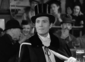 Movie still from “The Picture of Dorian Gray” (1945), directed by Albert Lewin – A man wearing a top hat and holding a cane; Medium shot, Over the shoulder angle