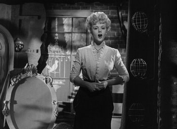 Movie still from “The Picture of Dorian Gray” (1945), directed by Albert Lewin – An old photo of a woman standing in front of a brick wall; Medium shot, Low angle