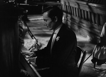 Movie still from “The Picture of Dorian Gray” (1945), directed by Albert Lewin – A black and white photo of a man sitting at a piano; Close Up shot, High angle