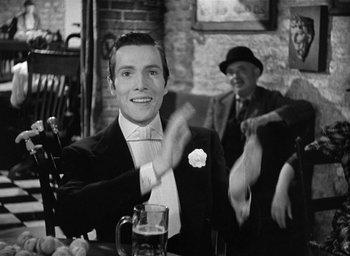 Movie still from “The Picture of Dorian Gray” (1945), directed by Albert Lewin – A black and white photo of a man at a bar; Medium shot, Over the shoulder angle