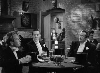 Movie still from “The Picture of Dorian Gray” (1945), directed by Albert Lewin – A black and white photo of men sitting at a table; Medium shot, High angle
