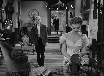 Movie still from “The Picture of Dorian Gray” (1945), directed by Albert Lewin – A man and a woman standing in a living room; Wide shot, Over the shoulder angle