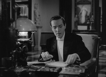 Movie still from “The Picture of Dorian Gray” (1945), directed by Albert Lewin – A black and white photo of a man writing; Medium shot, High angle