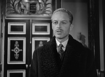 Movie still from “The Picture of Dorian Gray” (1945), directed by Albert Lewin – A black and white photo of a man wearing a coat and tie; Close Up shot, Low angle