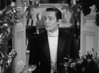 Movie still from “The Picture of Dorian Gray” (1945), directed by Albert Lewin – A man in a tuxedo standing next to a door way; Medium shot, Over the shoulder angle