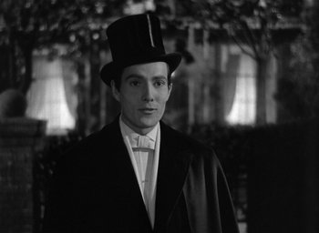 Movie still from “The Picture of Dorian Gray” (1945), directed by Albert Lewin – A young man wearing a top hat and a tuxedo; Medium shot, Low angle