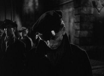 Movie still from “The Picture of Dorian Gray” (1945), directed by Albert Lewin – A man wearing a hat and a coat; Close Up shot, Low angle