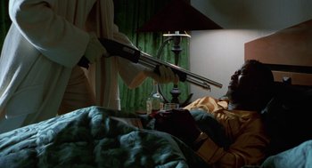 Movie still from “The Players Club” (1998), directed by Ice Cube – A man in a yellow shirt holding a pair of metal pipes; Medium shot, Low angle