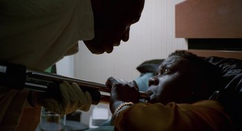 Movie still from “The Players Club” (1998), directed by Ice Cube – A man is holding a metal rod to a woman's face; Close Up shot, Low angle
