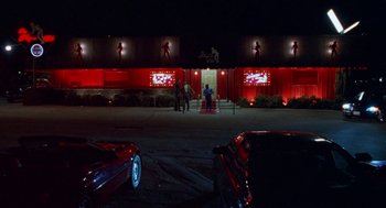 Movie still from “The Players Club” (1998), directed by Ice Cube – Two men standing in front of a building at night; Extreme Wide shot, Low angle