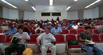 Movie still from “The Players Club” (1998), directed by Ice Cube – A group of people sitting in rows of chairs; Extreme Wide shot, High angle