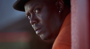 Movie still from “The Players Club” (1998), directed by Ice Cube – A person wearing an orange shirt; Close Up shot, Low angle