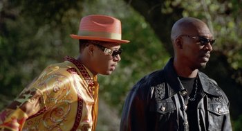 Movie still from “The Players Club” (1998), directed by Ice Cube – A man wearing a hat and sunglasses next to another man wearing a jacket; Medium shot, Over the shoulder angle