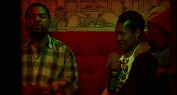 Movie still from “The Players Club” (1998), directed by Ice Cube – A man and a woman sitting next to each other; Medium shot, Low angle