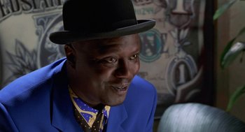 Movie still from “The Players Club” (1998), directed by Ice Cube – A man wearing a blue suit and a hat; Close Up shot, Low angle