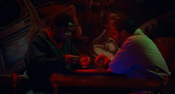 Movie still from “The Players Club” (1998), directed by Ice Cube – Two men sitting at a table in a dark room; Medium shot, High angle