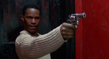 Movie still from “The Players Club” (1998), directed by Ice Cube – A man holding a gun in his hand; Close Up shot, High angle