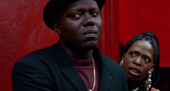 Movie still from “The Players Club” (1998), directed by Ice Cube – A man wearing a black hat and a black jacket; Close Up shot, Low angle