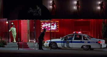 Movie still from “The Players Club” (1998), directed by Ice Cube – A police car parked on the side of the street; Wide shot, Low angle