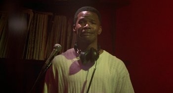 Movie still from “The Players Club” (1998), directed by Ice Cube – A man with headphones and a microphone in front of a microphone; Close Up shot, Low angle