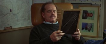 Movie still from “The Pledge” (2001), directed by Sean Penn – A man sitting in a chair looking at an ipad; Close Up shot, Low angle