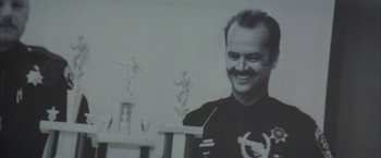 Movie still from “The Pledge” (2001), directed by Sean Penn – A black and white photo of a man smiling; Close Up shot, Low angle