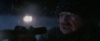 Movie still from “The Pledge” (2001), directed by Sean Penn – A man with a flashlight in the snow; Close Up shot, Low angle