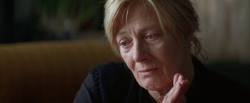 Movie still from “The Pledge” (2001), directed by Sean Penn – An older woman sitting in front of a window; Close Up shot, Over the shoulder angle