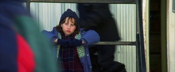Movie still from “The Pledge” (2001), directed by Sean Penn – A young girl wearing a blue coat and a blue hat; Medium shot, High angle