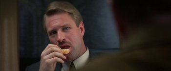 Movie still from “The Pledge” (2001), directed by Sean Penn – A person eating a doughnut; Close Up shot, Low angle