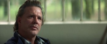 Movie still from “The Pledge” (2001), directed by Sean Penn – A person sitting on a couch; Close Up shot, Over the shoulder angle